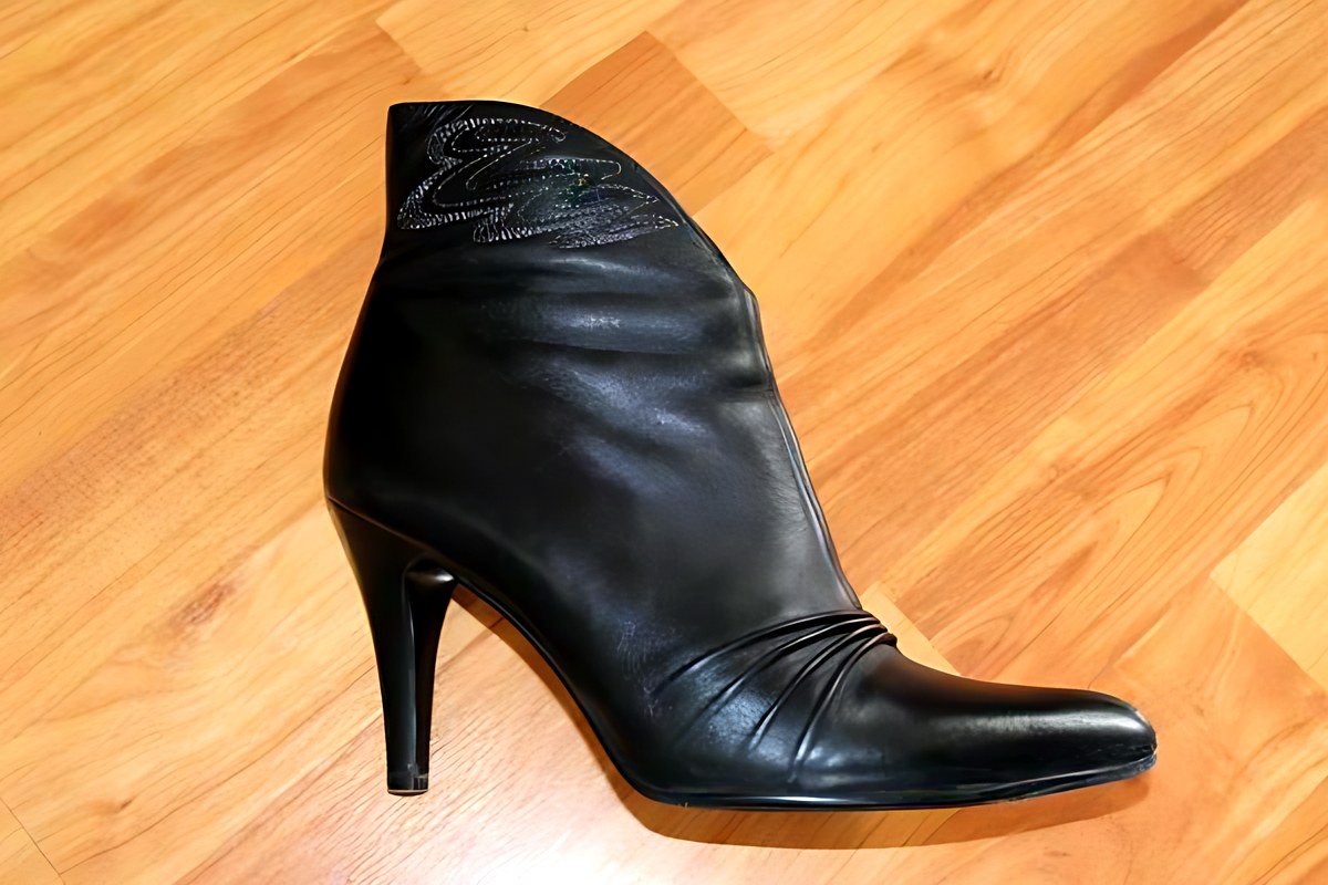 Black ankle boot on a wooden floor
